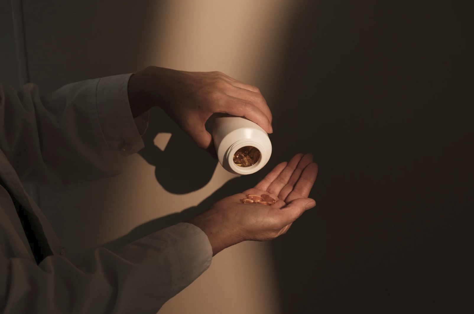 Person Holding Bottle of Vitamin Capsules